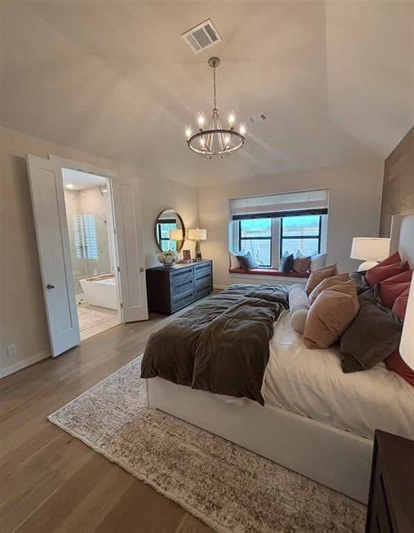 17703 Monarch Vista Ln, Conroe, TX 77302 - bedroom featuring a chandelier, wood finished floors, baseboards, ensuite bath, and vaulted ceiling