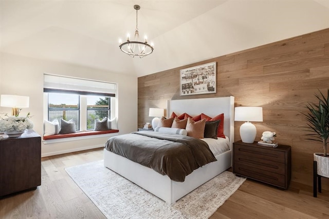 17703 Monarch Vista Ln, Conroe, TX 77302 - bedroom with a chandelier, wood finished floors, lofted ceiling, wooden walls, and an accent wall