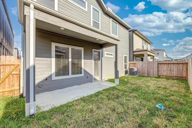 rear view of property featuring a fenced backyard, a patio area, central air condition unit, and a yard