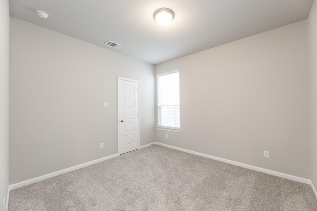 empty room featuring visible vents, carpet, and baseboards