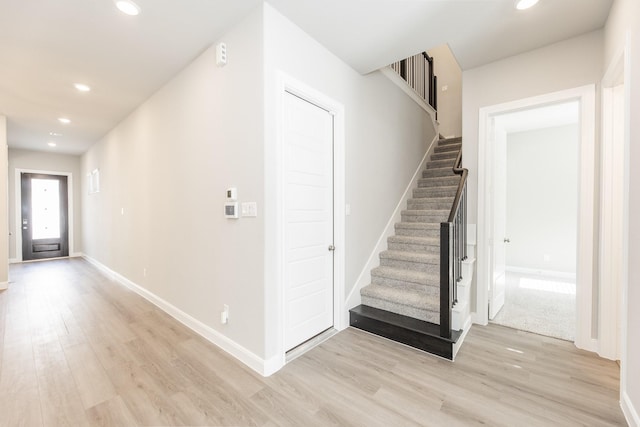 interior space with recessed lighting, baseboards, stairway, and light wood-type flooring
