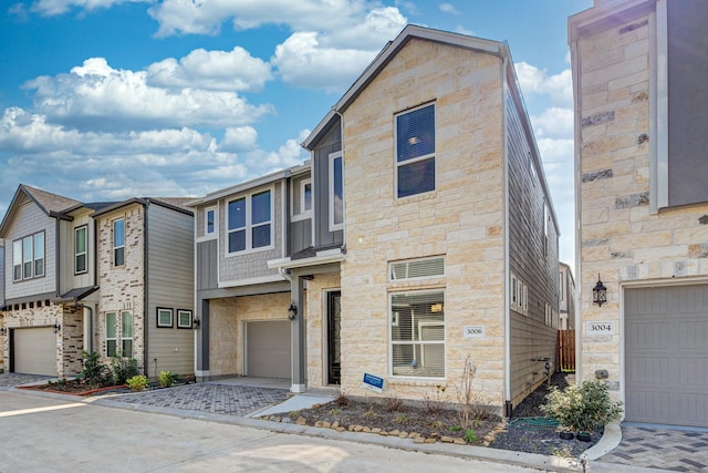 view of front of property with an attached garage, driveway, and stone siding