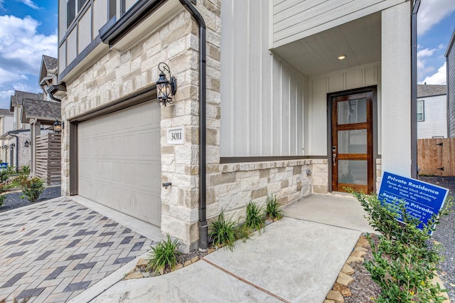 3011 Valley Peak Dr, Houston, TX 77063 - view of exterior entry featuring board and batten siding, driveway, and stone siding