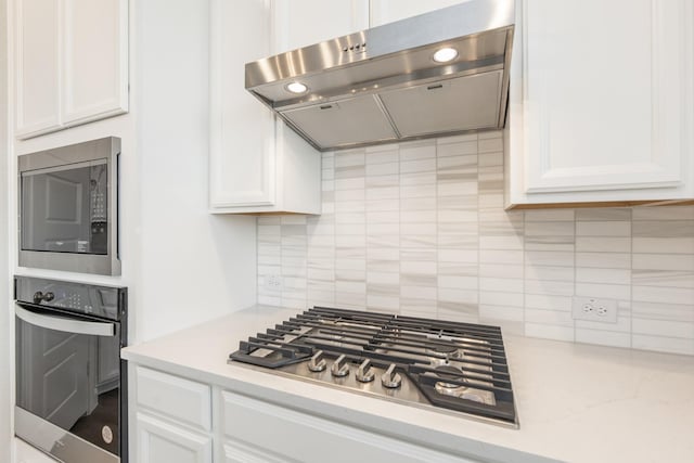 3011 Valley Peak Dr, Houston, TX 77063 - kitchen featuring light countertops, white cabinetry, appliances with stainless steel finishes, and under cabinet range hood