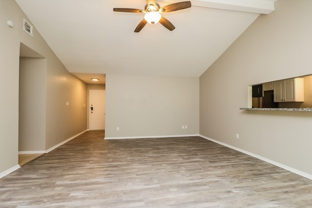 unfurnished living room featuring baseboards, light wood-style floors, ceiling fan, and vaulted ceiling
