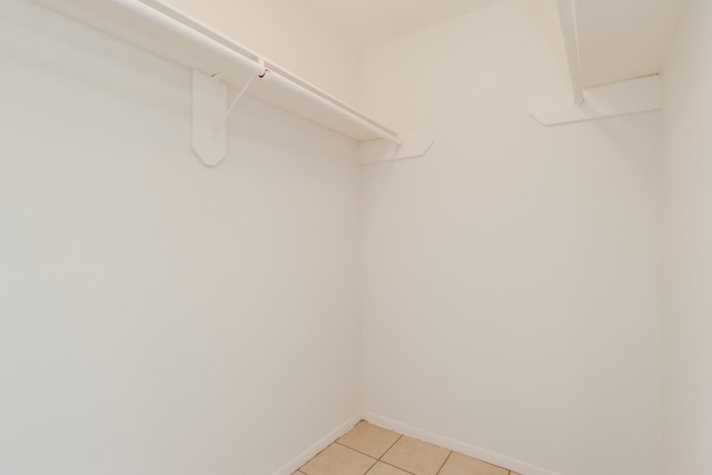 spacious closet with light tile patterned floors