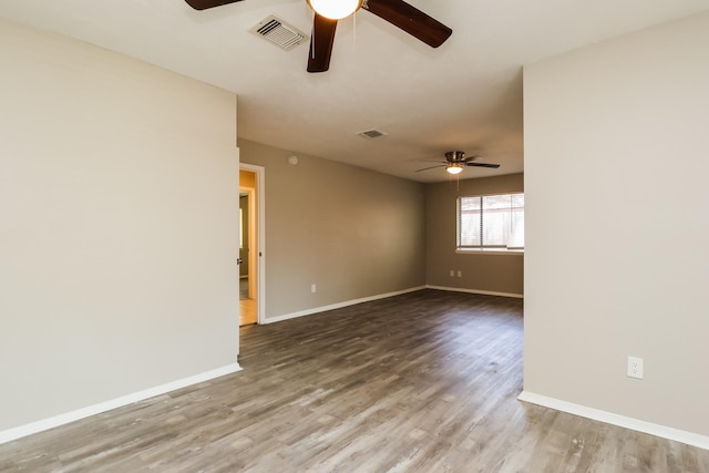 unfurnished room featuring visible vents, a ceiling fan, and wood finished floors