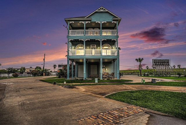 coastal inspired home with driveway and a balcony