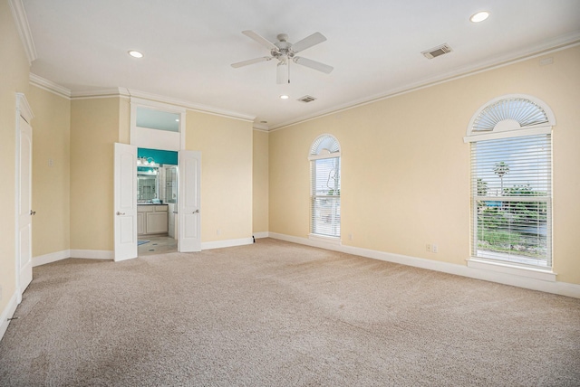 empty room featuring crown molding, baseboards, and light colored carpet