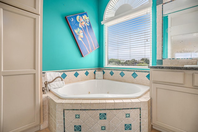 full bath with vanity and a jetted tub