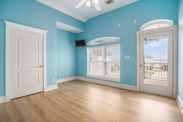 interior space featuring baseboards, a ceiling fan, wood finished floors, and visible vents
