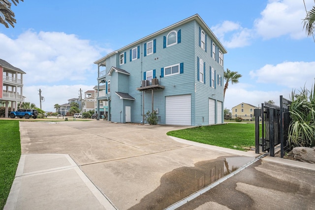 exterior space with an attached garage, a lawn, driveway, and a residential view