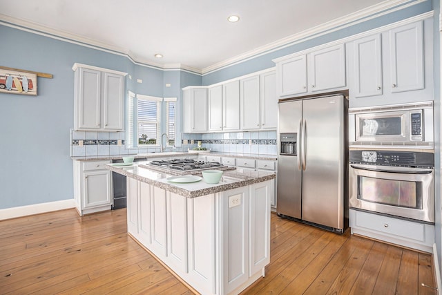 kitchen featuring light countertops, white cabinetry, a sink, backsplash, and stainless steel appliances