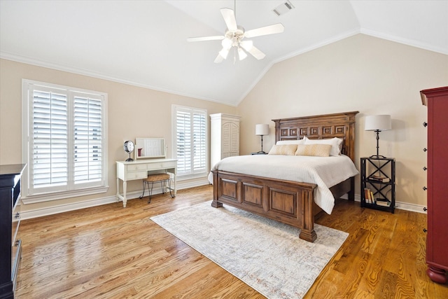 bedroom featuring crown molding, wood finished floors, vaulted ceiling, and visible vents