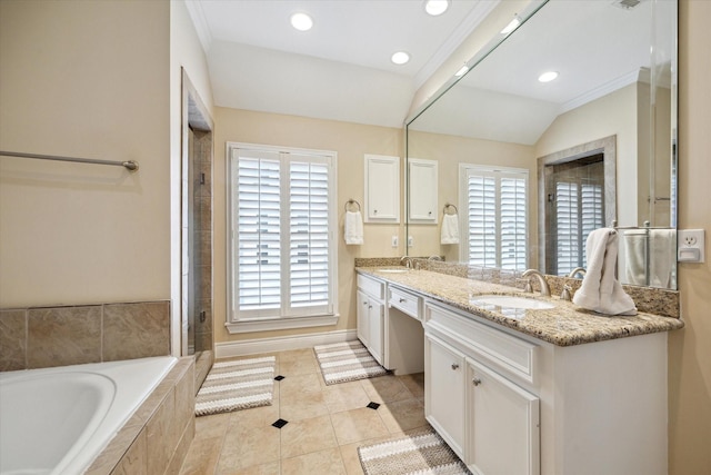 bathroom featuring a relaxing tiled tub, a sink, tile patterned flooring, and double vanity
