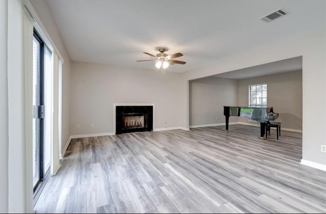 unfurnished living room featuring visible vents, a ceiling fan, baseboards, and light wood-type flooring