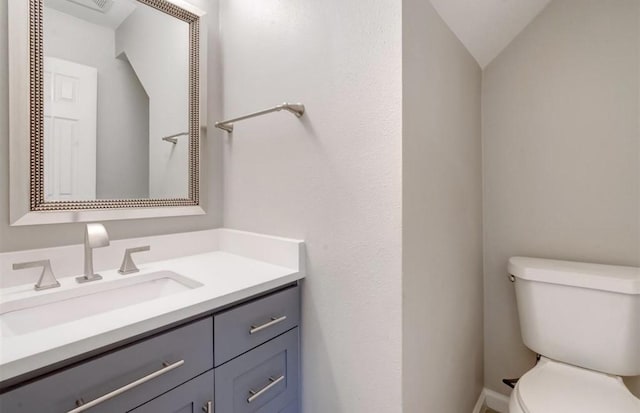 half bathroom with vanity and toilet