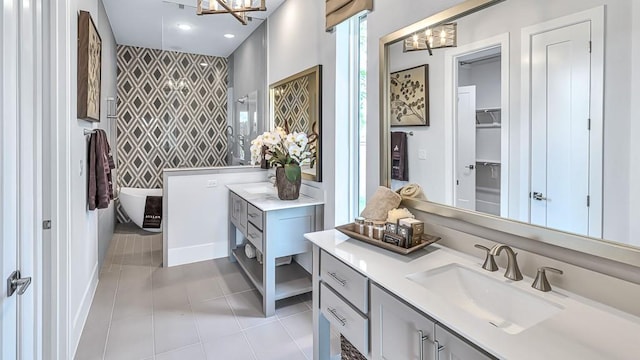 bathroom with vanity, an accent wall, a notable chandelier, and wallpapered walls