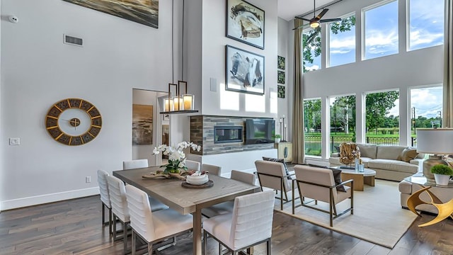 dining space with plenty of natural light, visible vents, and a towering ceiling