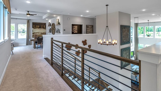 hall featuring baseboards, recessed lighting, a chandelier, and an upstairs landing