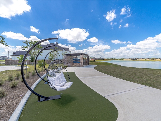 view of community featuring a lawn and a water view