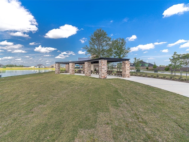 view of front of house featuring concrete driveway, a water view, and a front yard