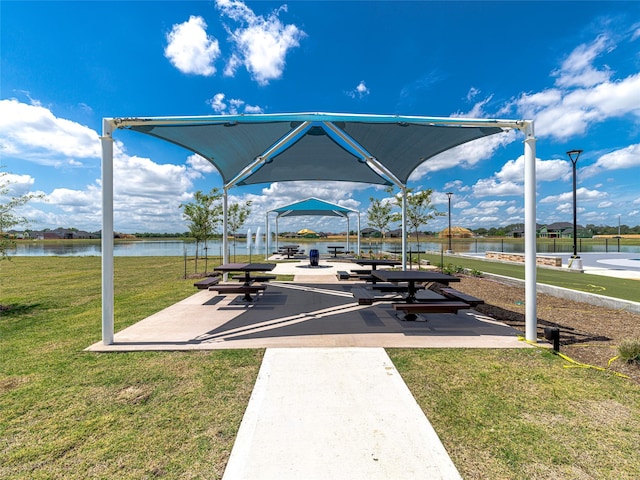 view of community featuring a lawn and a water view