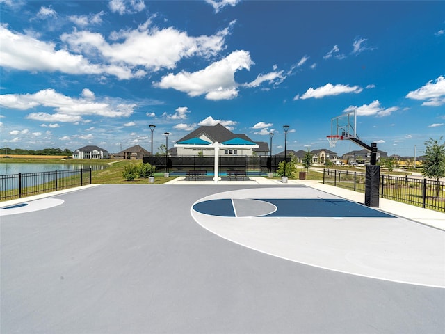 view of basketball court featuring a water view, fence, and community basketball court