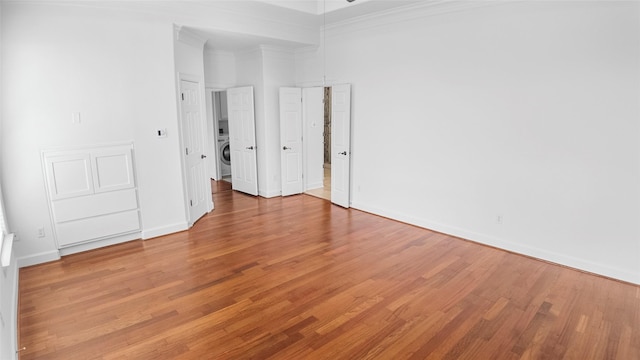 4524 Rose St, Houston, TX 77007 - unfurnished room with baseboards, washer / dryer, ornamental molding, and light wood-type flooring