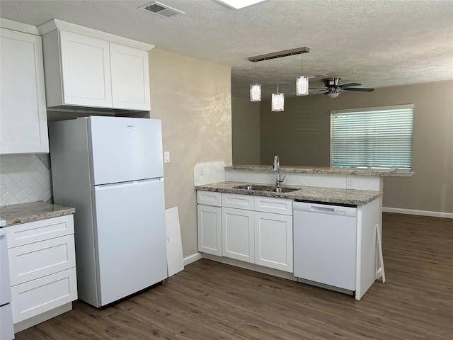 105 Will St, Willis, TX 77378 - kitchen with visible vents, tasteful backsplash, a sink, a peninsula, and white appliances
