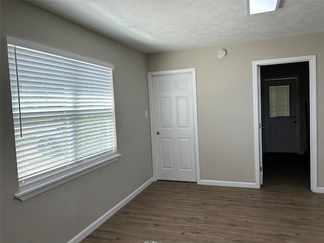 105 Will St, Willis, TX 77378 - unfurnished bedroom with baseboards, a textured ceiling, and wood finished floors