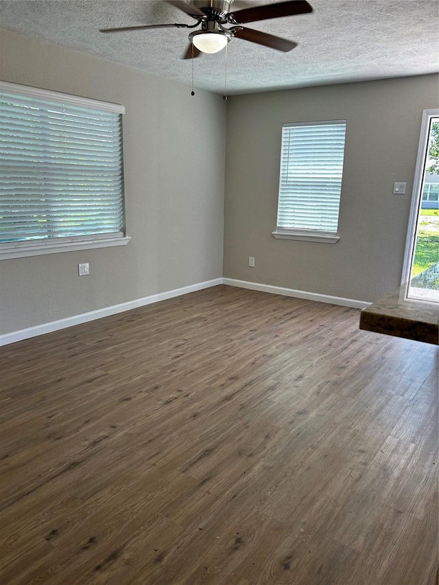 105 Will St, Willis, TX 77378 - empty room with baseboards, ceiling fan, dark wood finished floors, and a textured ceiling