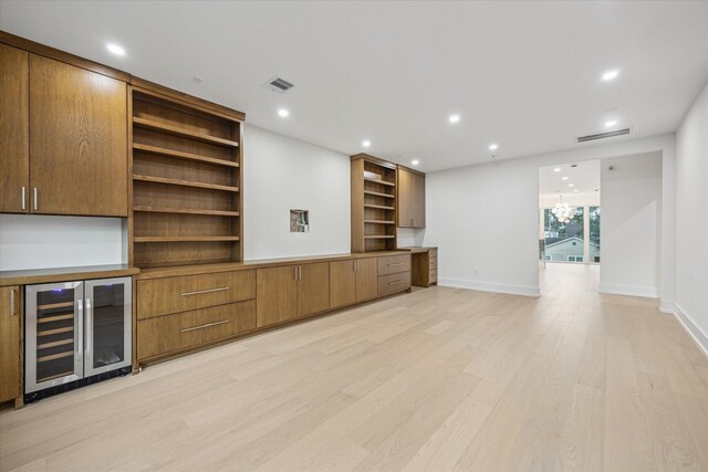 1550 Gardenia Dr, Houston, TX 77018 - unfurnished living room featuring beverage cooler, light wood-style flooring, baseboards, and recessed lighting