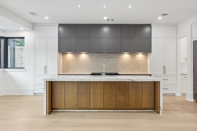 1550 Gardenia Dr, Houston, TX 77018 - kitchen with light stone countertops, backsplash, a sink, a spacious island, and recessed lighting