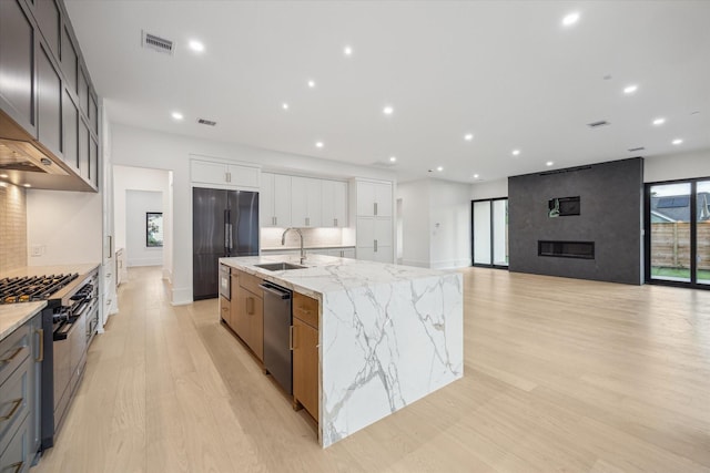 1550 Gardenia Dr, Houston, TX 77018 - kitchen with dishwasher, refrigerator, gas stove, light wood-style floors, and a large island with sink