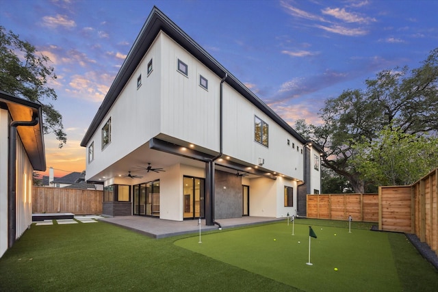 1550 Gardenia Dr, Houston, TX 77018 - back of house at dusk with a putting area, ceiling fan, a patio, and a fenced backyard