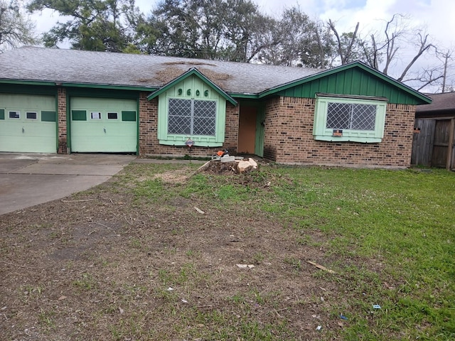 ranch-style house featuring fence, an attached garage, a front lawn, brick siding, and driveway
