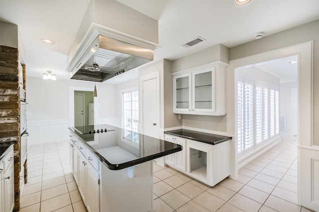 kitchen with visible vents, dark countertops, glass insert cabinets, black electric stovetop, and white cabinetry