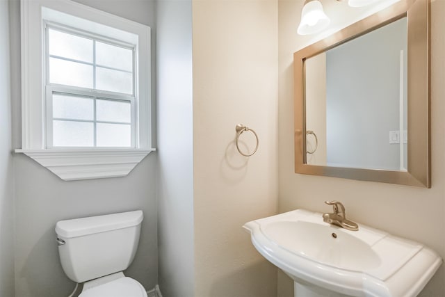 half bath featuring toilet and a sink