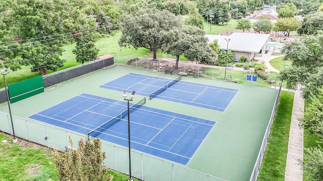 view of tennis court with fence and community basketball court