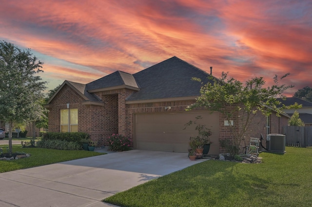 single story home with a garage, a front lawn, a shingled roof, and concrete driveway