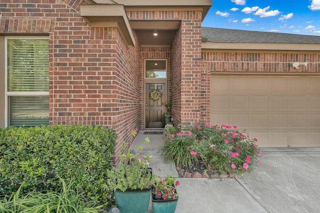 entrance to property with brick siding and a garage
