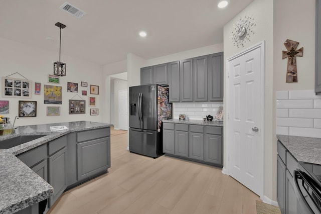 kitchen featuring gray cabinets, visible vents, electric range oven, a sink, and refrigerator with ice dispenser