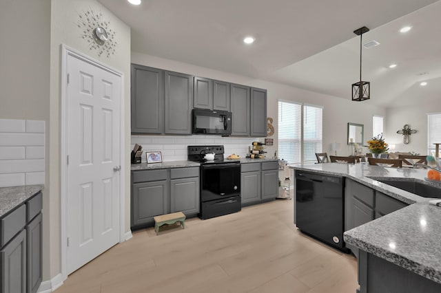 kitchen with a sink, decorative backsplash, gray cabinets, and black appliances