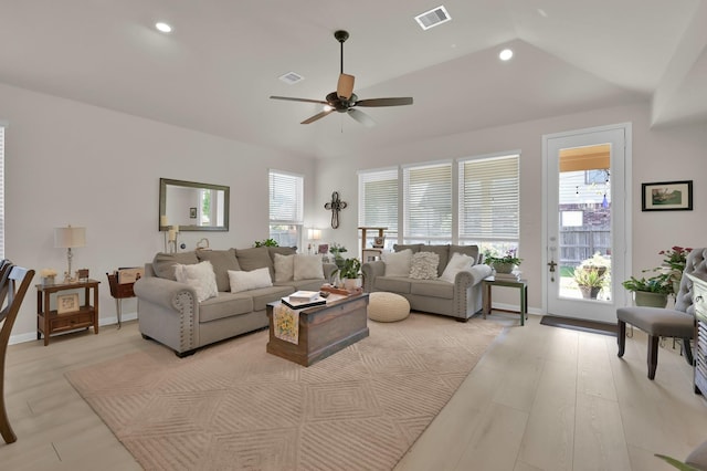 living area with a wealth of natural light, a ceiling fan, and visible vents