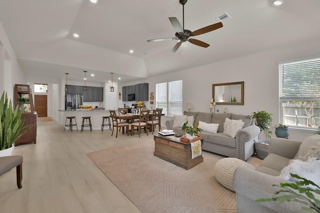 living room featuring visible vents, ceiling fan, recessed lighting, light wood finished floors, and vaulted ceiling