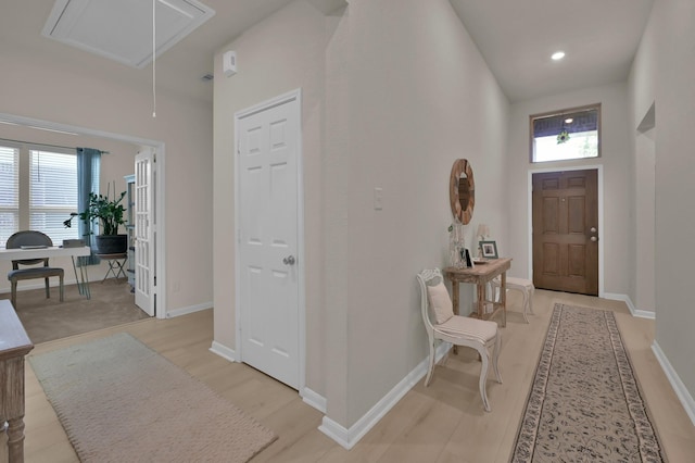 foyer entrance with baseboards and light wood-style flooring