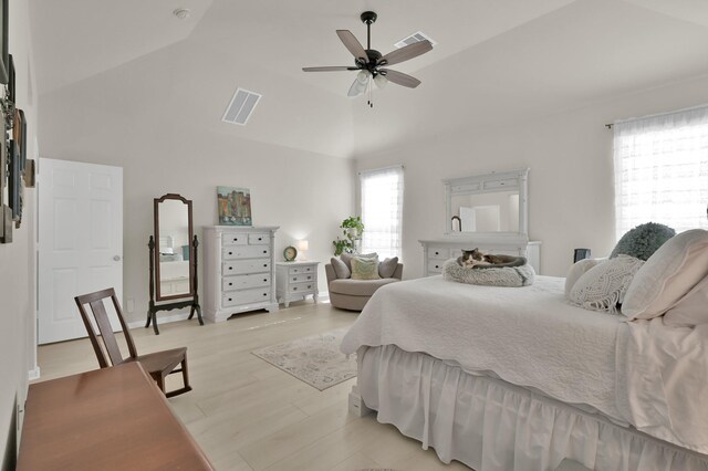 bedroom with light wood-style floors, high vaulted ceiling, a ceiling fan, and visible vents