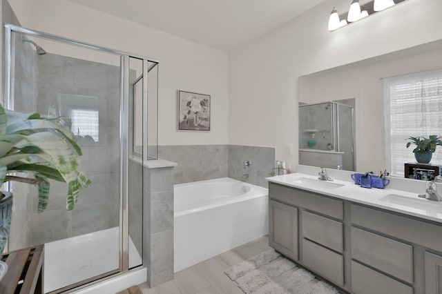 bathroom with a sink, double vanity, a stall shower, and a bath