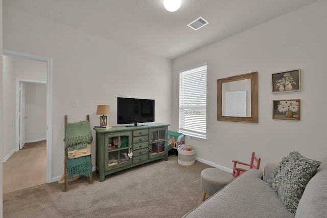 living area featuring baseboards, visible vents, and carpet